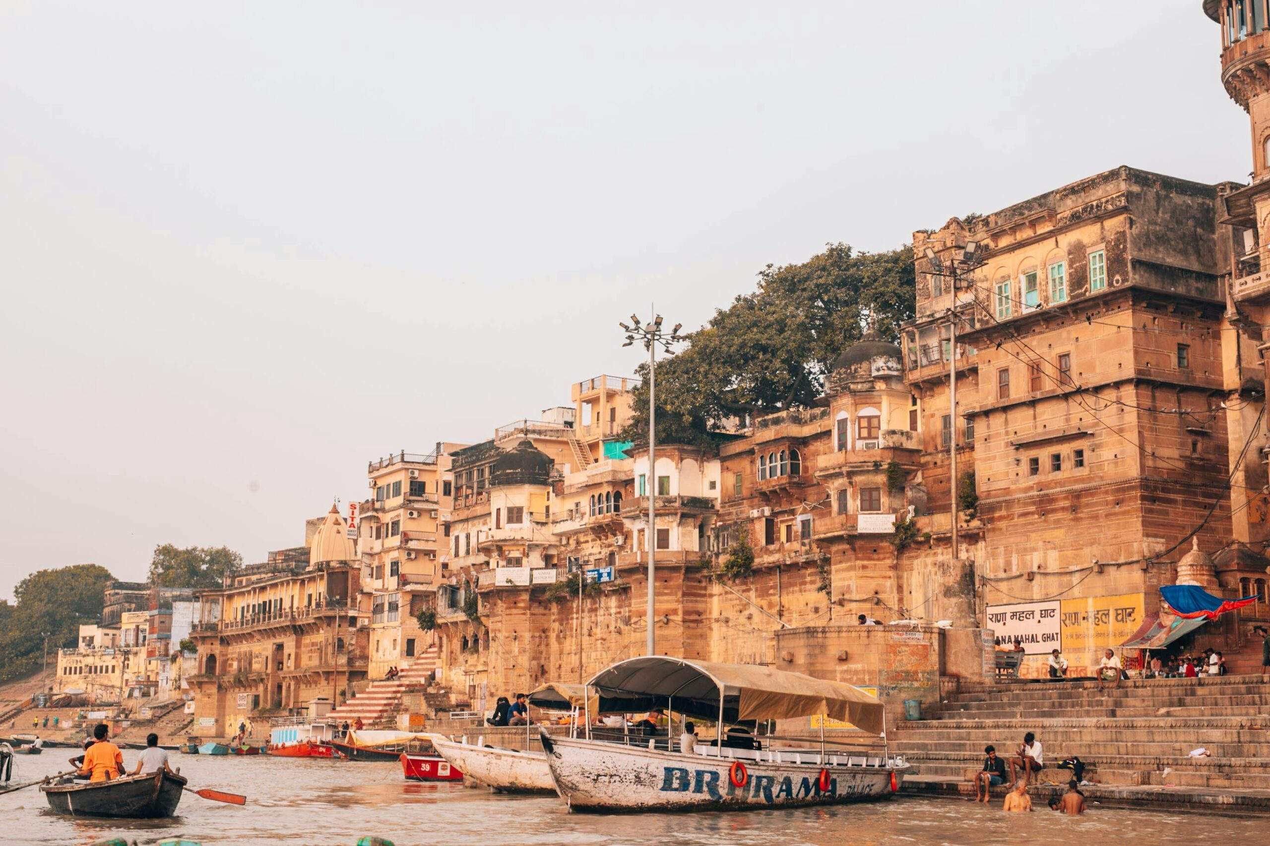 Picturesque view of Varanasi ghats along the Ganges River with bustling boats and ancient architecture.